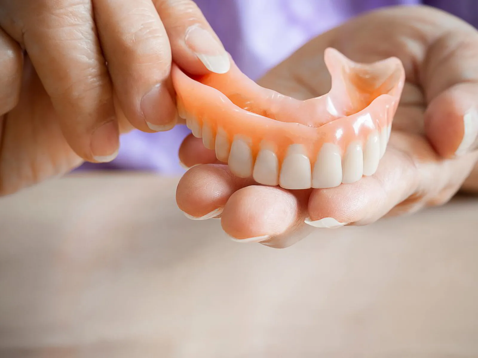 Patient smiling confidently with new dentures